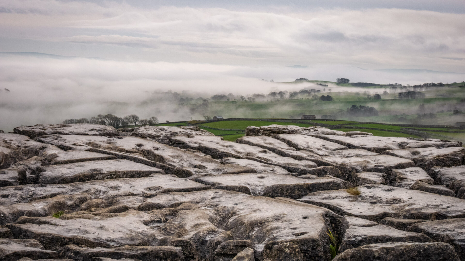 Looking over a misty Malhamdale from the top of Malham Cove. Inverted cloud means the valley floor is covered.