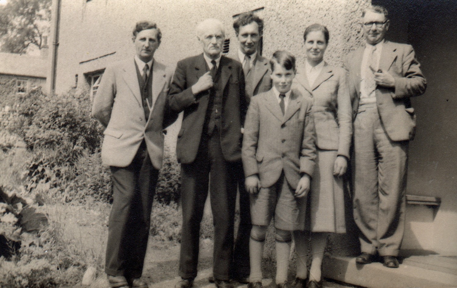 Archive photograph. In the summer of 1948 the YHA arranged a dedication of Malham Hostel to be the John Dower Memorial Hostel. A plaque in the dining room of the hostel was unveiled by G.M.Trevelyan, the President of the YHA. Left to right in the photograph are:  Arthur Raistrick; GM Trevelyan; John Dower’s brother Arthur Dower; John Dower’s youngest son, Robin Dower; Pauline Dower; and a man holding a pipe.